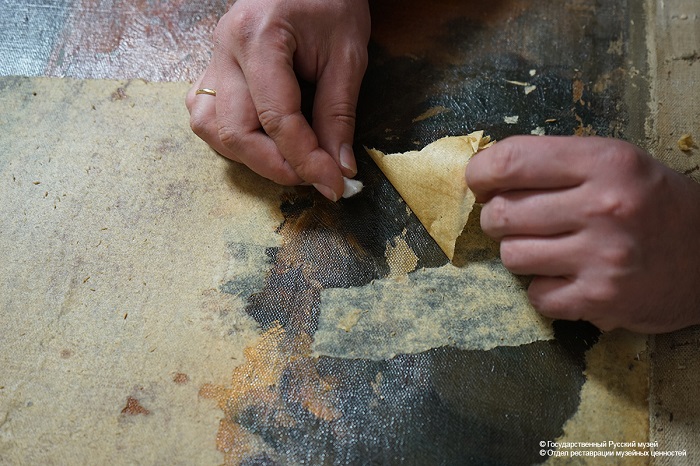 Процесс снятия бумажной заклейки. | Фото:  restoration.rusmuseum.ru.