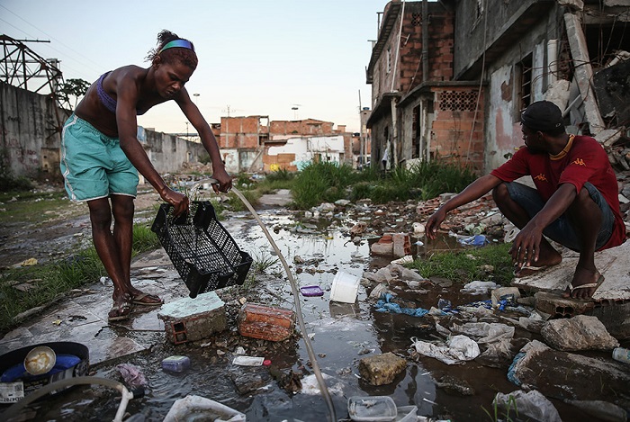Люди моют посуду на улицах, просто поливая ее из лежащих на земле шлангов.