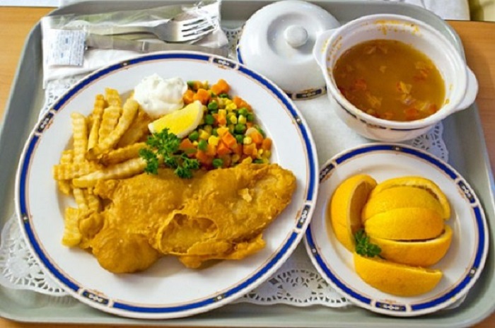 Рыба и картофель фри, овощи и суп.