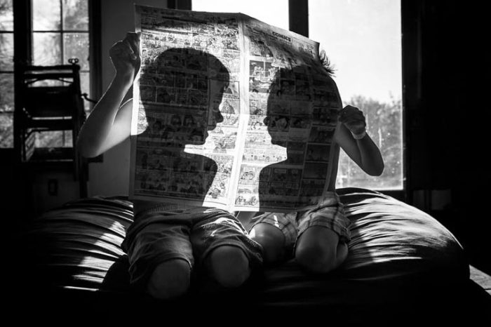 Игра фотографа с тенью детей, читающих комиксы в газете. Фотограф: Эшли Карлтон, США.