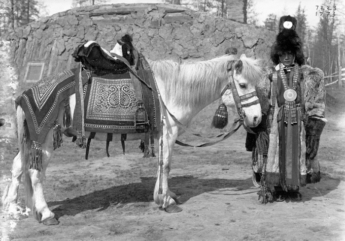 Невеста якутка из зажиточной семьи рядом с лошадью. Россия, Якутия, 1902 год.