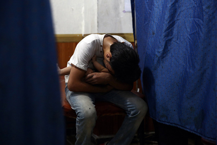 Мужчина держит на руках свою племянницу. Он только что потерял свою сестру, мать ребенка. Дума, Сирия. 24 августа 2015г.