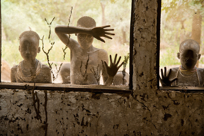 Дети из племени Кара смотрят сквозь окна, долина Омо, Эфиопия, 2013г.