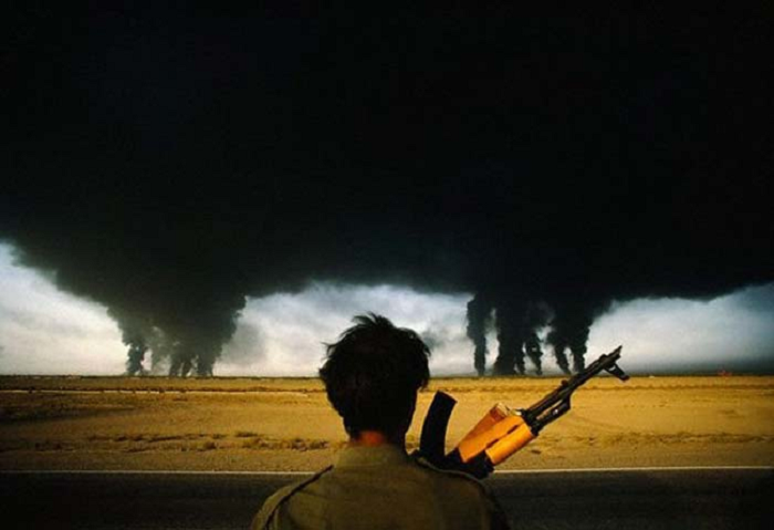 Иранские войска наблюдают, как горят нефтяные месторождения, подожжённые иракскими войсками во время войны в Персидском заливе. (1990).