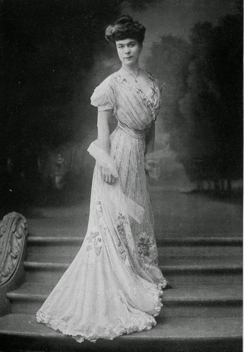 Девушка в платье из дорогого шелка, украшенного аппликацией из белого бисера.