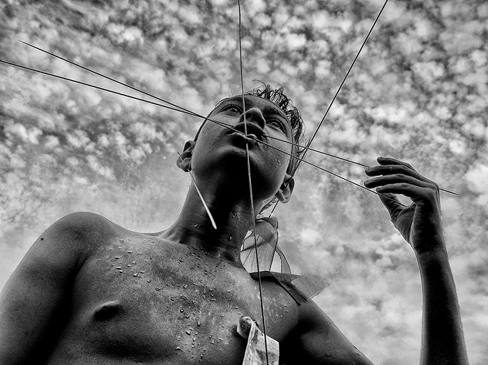 Верующий пронзает свое лицо спицами во время индуистского фестиваля Чарак Пуджа в Западной Бенгалии, Индия. Фотограф - Avishek Das.