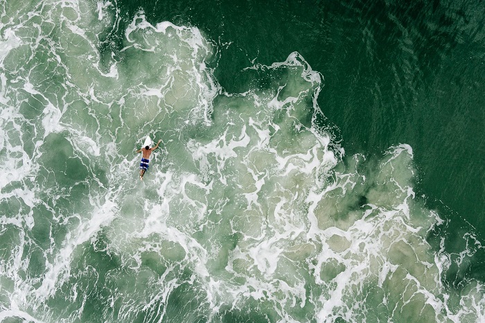 Отчаянный серфингист на красивых морских волнах. Фотограф - Chris Schmid.