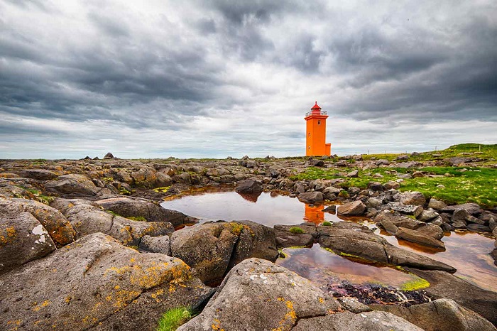 Красивый, оранжевый маяк высотой в одиннадцать с половиной метров стоит на полуострове Рейкьянес.