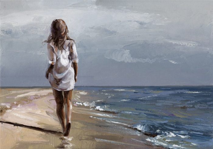 Девушка прогуливается по береговой линии моря.