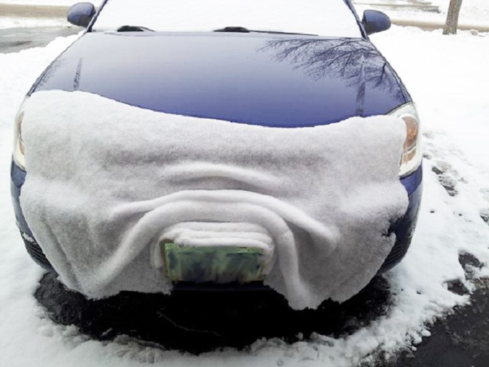 Шар снігу накритий бампер машини.