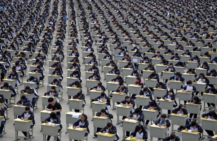 Студенты сдают экзамен на детской площадке средней школы под открытым небом в Yichuan, провинция Шэньси. Более 1700 первокурсников приняли участие в экзамене в 2015 году.