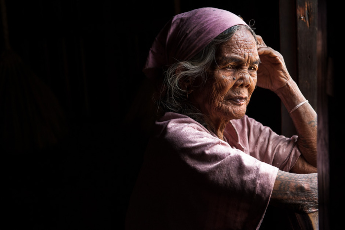 Женщина народности калинга задумчиво смотрит в окно. Татуировки на руках используются как украшения, а также свидетельствуют о принадлежности к определенному племени.