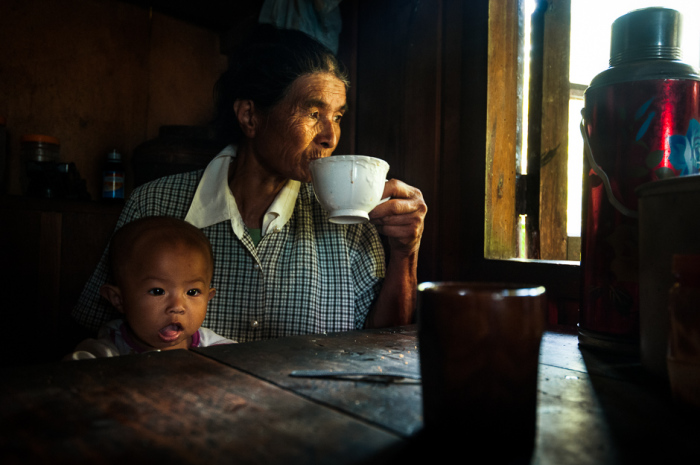 Канканайская женщина с внуком пьет кофе во время полуденного перерыва от работы в рисовом поле.